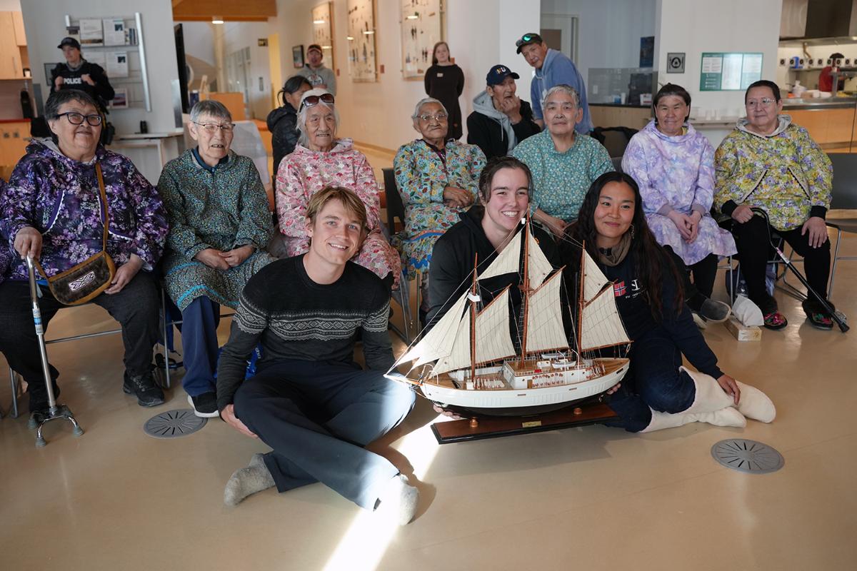 Mennesker med en modellskute foran